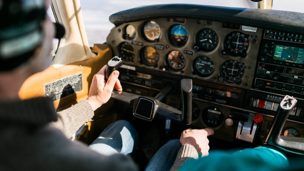 A young aspiring pilot sitting in a small aircraft cockpit, looking out at the runway, ready to begin their flight training journey.