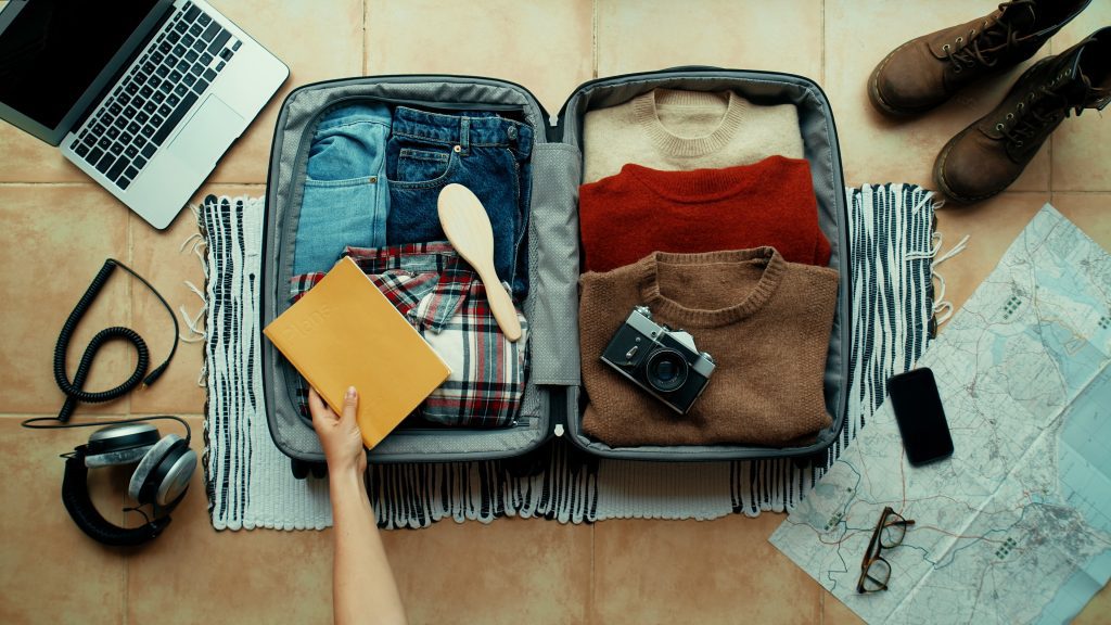 A neatly packed carry-on suitcase with organized clothing, toiletries, and travel essentials.